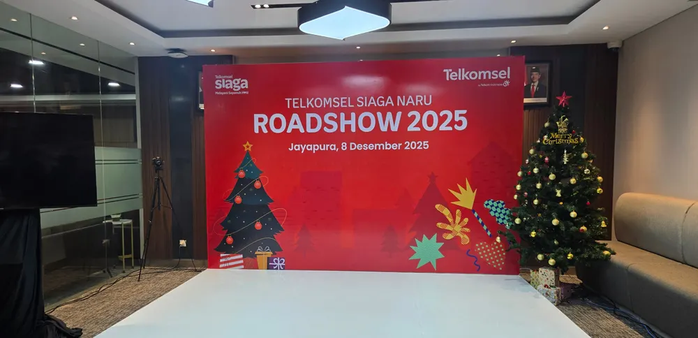 Backdrop dan panggung rendah terpasang menghadap area duduk peserta.