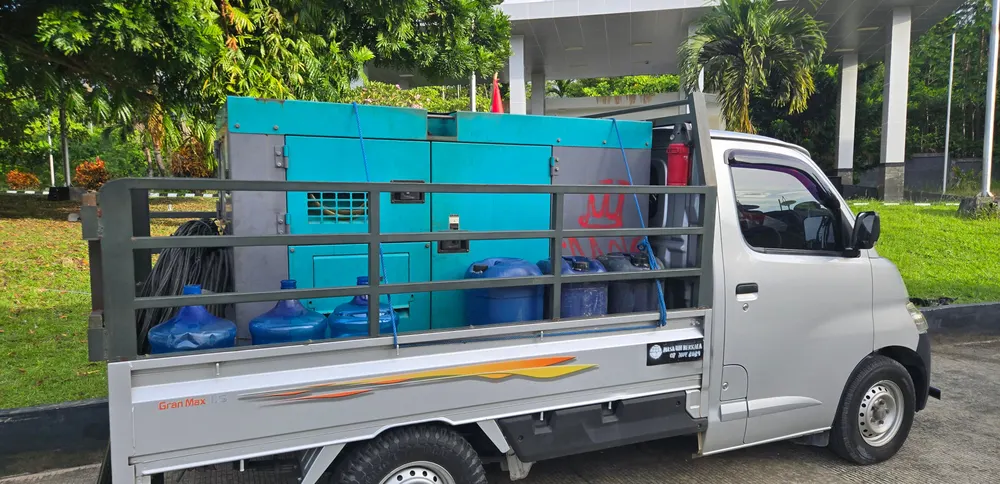 Kendaraan angkut berjeruji memuat peralatan produksi dan bersiap berangkat.