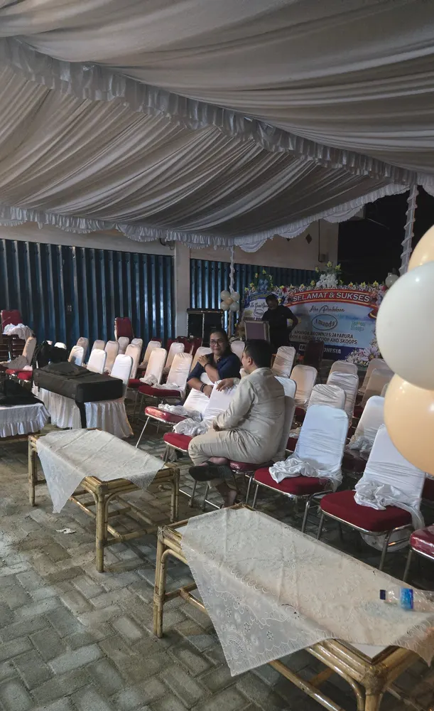 Kursi berbalut kain putih tertata rapi di bawah tenda dekorasi menjelang acara dimulai.